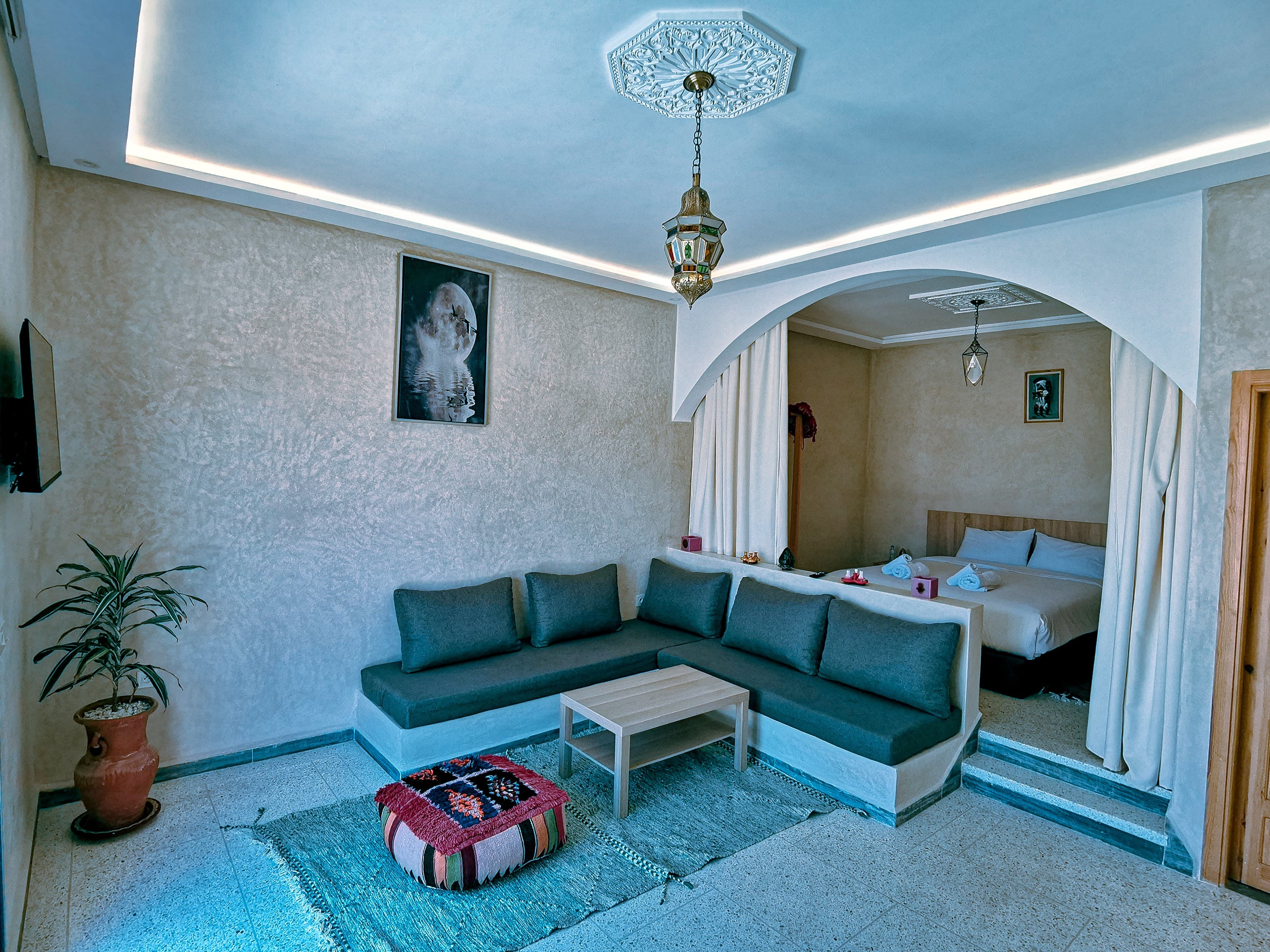 Living space with grey sofa and arch to bedroom